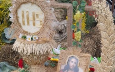 Zdjęcie ozdoby wykonanej na dożynki ze zboża i żyta, JHS i obar Jezusa Chrystusa.
